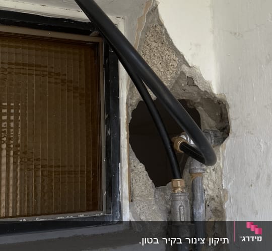 צינור שחור מחובר לקיר עם חלון קטן